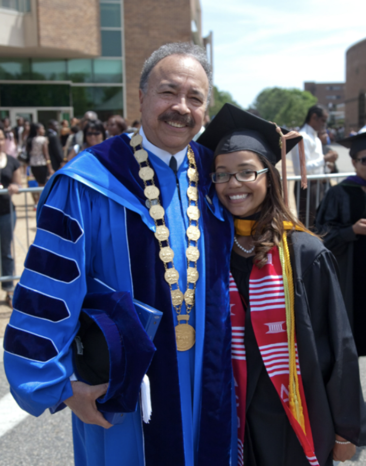 William R. Harvey, president of Hampton University, hugs a graduating student.