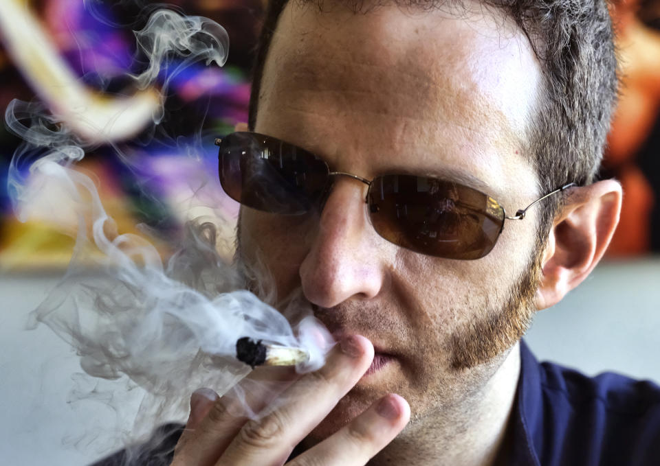 In this Saturday, Aug. 25, 2018 photo, Judd Weiss takes a puff of a pre-rolled marijuana cigarette at his house in the Bel Air section of Los Angeles. Weiss, CEO and founder of cannabis company Lit.Club, believes the industry needs to do still more. He suggests marketing products in a way that makes them look more than just respectable, but as the herbal equivalent of a fine bourbon or scotch. (AP Photo/Richard Vogel)