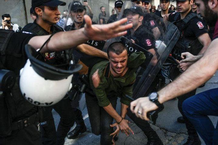 A plain-clothes police officer kicks a member of a group of LGBT rights activist as Turkish police prevent them from going ahead with Gay Pride (AFP/Getty Images)