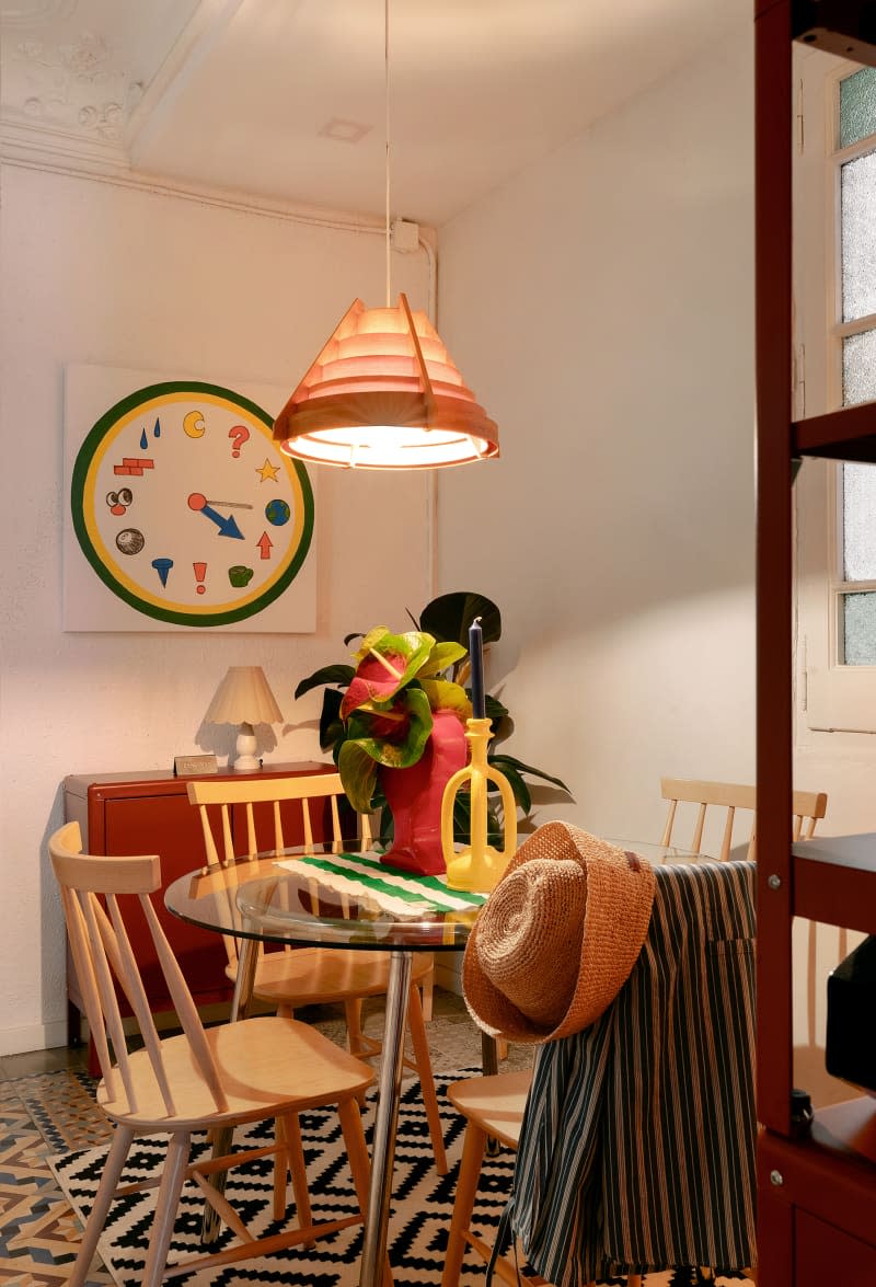 Pendant light hangs above round glass table.