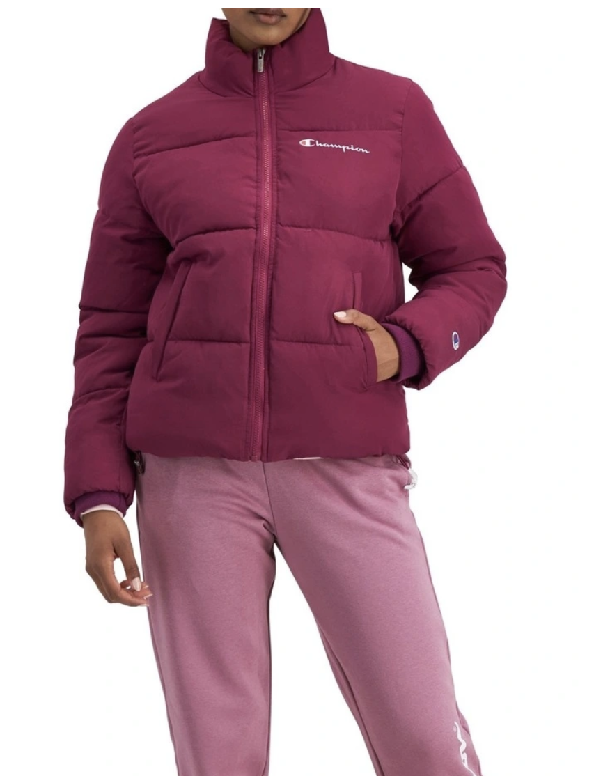 A woman stands one hand in wine puffer jacket with slim fit rose track pants 