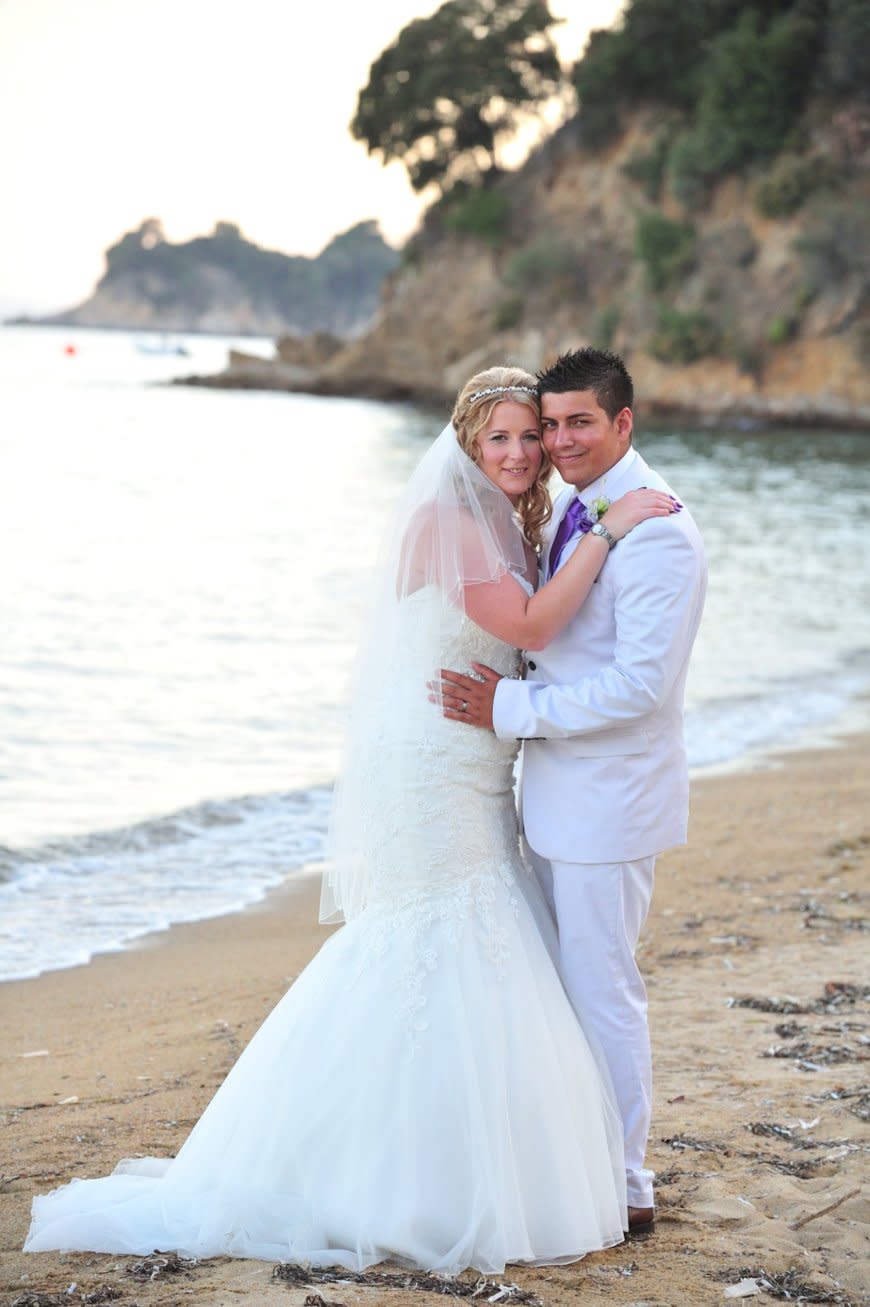 Danielle wedding day with Kyle, embracing on beach. (Supplied)