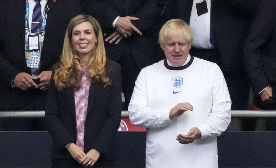 British Prime Minister Boris Johnson claps hands on the tribune beside his wife Carrie prior the Euro 2020 soccer championship final between England and Italy at Wembley stadium in London, Sunday, July 11, 2021. (AP Photo/Frank Augstein, Pool)