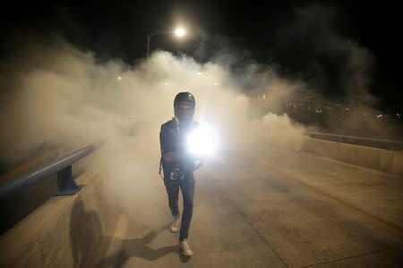 FILE PHOTO: A cameraman is seen amidst tear gas during a protest to mark the first anniversary of a contested presidential election with allegations of electoral fraud, in Tegucigalpa, Honduras November 26, 2018. REUTERS/Jorge Cabrera/File Photo