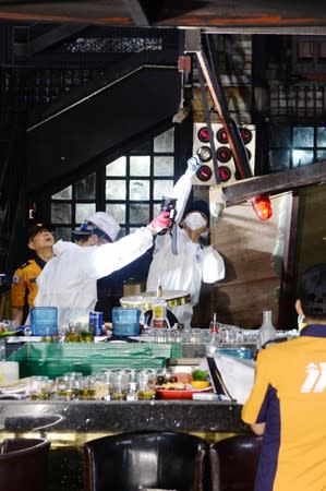 South Korean firefighters and officials examine the collapsed structure of a nightclub in Gwangj