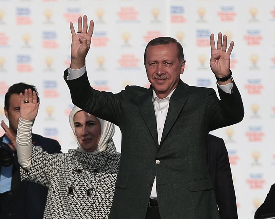 Turkish Prime Minister Recep Tayyip Erdogan, right, addresses supporters of his Justice and Development Party during a rally in Istanbul, Turkey, Sunday, March 23, 2014. Turkish fighter jets shot down a Syrian warplane after it violated Turkey's airspace Sunday, Erdogan said, in a move likely to ramp up tensions between the two countries already deeply at odds over Syria's civil war. Erdogan is fighting corruption allegations against his government a week before local elections that are seen as a referendum over his rule. His wife Emine Erdogan stands at the left(AP Photo/Emrah Gurel)