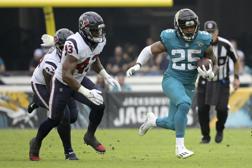 FILE - Jacksonville Jaguars running back James Robinson (25) runs past Houston Texans defensive tackle Jaleel Johnson (93) and middle linebacker Neville Hewitt (43) during the first half of an NFL football game, Sunday, Dec. 19, 2021, in Jacksonville, Fla. James Robinson, the third-year pro is working his way back from a torn Achilles tendon in his left leg sustained at the New Yok Jets in December. He was cleared to begin practicing in full last month, but he didn’t play in the preseason and hasn’t endured more than thud contact in training camp.(AP Photo/Phelan M. Ebenhack, File)