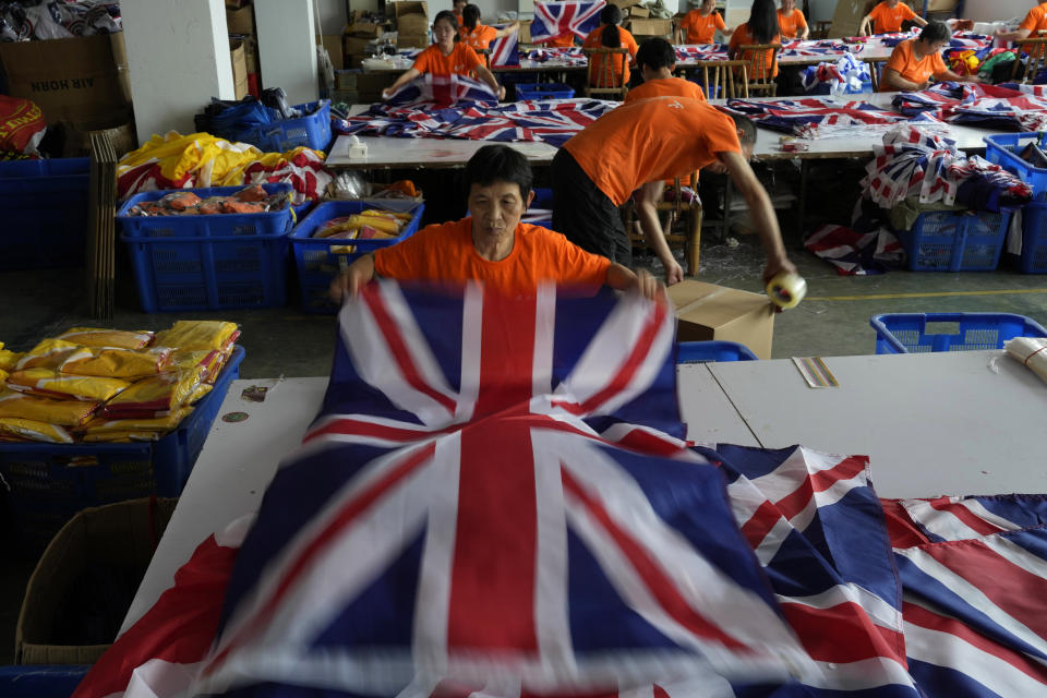 A worker packs British flags to prepare for shipping at the Shaoxing Chuangdong Tour Articles Co. factory in Shaoxing, in eastern China's Zhejiang province, Friday, Sept. 16, 2022. Ninety minutes after Queen Elizabeth II died, orders for thousands of British flags started to flood into the factory south of Shanghai. (AP Photo/Ng Han Guan)