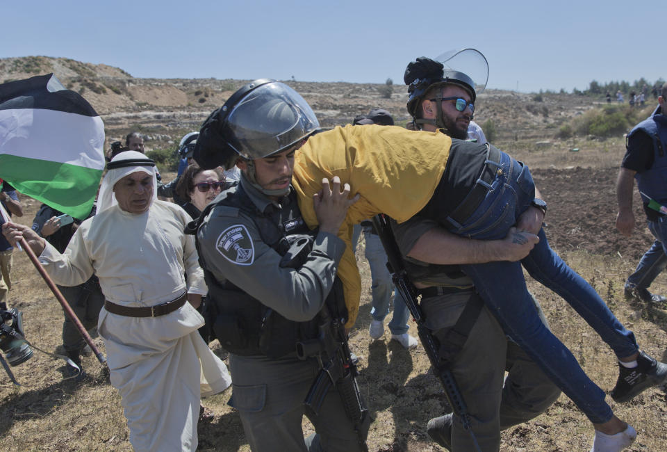 Israeli border police arrest an unconscious protester during a rally supporting Palestinian prisoners in Israeli jails, outside Ofer military prison, near the West Bank city of Ramallah, Thursday, Aug. 22. 2019. Israeli border police said the man was conscious when he was arrested. (AP Photo/Nasser Nasser)