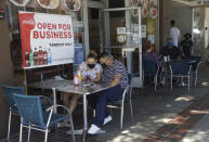 FILE - In this July 18, 2020, file photo, Josefina Pacheco, front left, and her husband Norberto wait to have a meal served outside at a restaurant in Burbank, Calif. Los Angeles County announced new coronavirus-related restrictions Sunday, Nov. 22, 2020, that will prohibit in-person dining for at least three weeks as cases rise at the start of the holiday season and officials statewide begged Californians to avoid traveling or gathering in groups for Thanksgiving. The new restrictions in Los Angeles County, the nation's most populous, came as the California Department of Health and Human Services reported more than 15,000 coronavirus cases statewide Saturday, by far the highest level since the pandemic began in March. Another 14,000 cases were recorded Sunday. (AP Photo/Marcio Jose Sanchez, File)