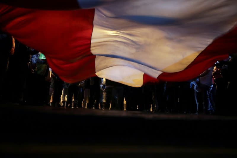 Demonstrators hold a national flag during protests following the impeachment of President Martin Vizcarra, in Lima