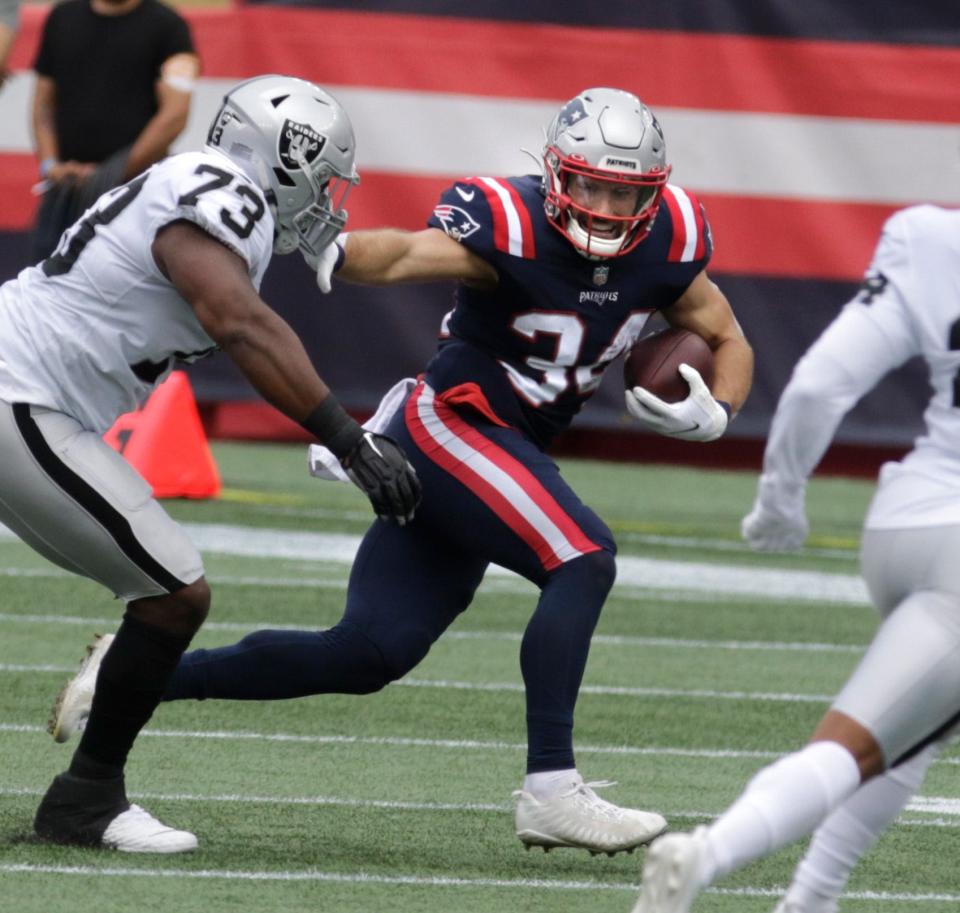 Patriots running back, Rex Burkhead, moves around Raiders defender Maurice Hurst on a first half run during the first half of Sunday's game in Foxboro.