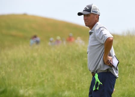 Jun 14, 2017; Erin, WI, USA; Jim Mackay known as "Bones" as the caddie for Phil Mickelson (not pictured) looks over the 12th green during a practice round of the U.S. Open golf tournament at Erin Hills. Mandatory Credit: Michael Madrid-USA TODAY Sports