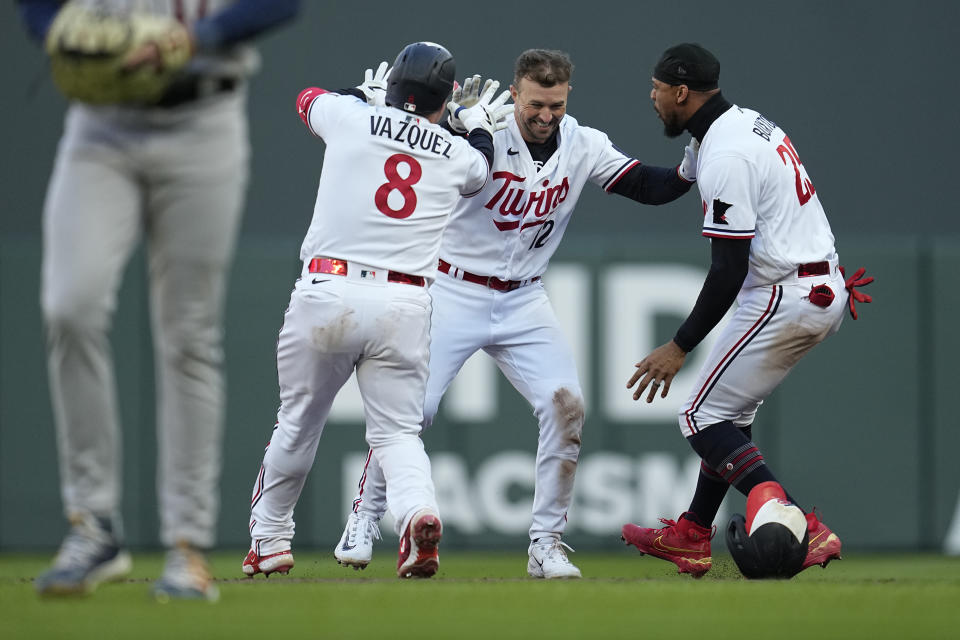 Minnesota Twins' Kyle Farmer, middle, celebrates with Christian Vazquez (8) and Byron Buxton after driving in the winning run during the 10th inning of the team's baseball game against the Houston Astros, Friday, April 7, 2023, in Minneapolis. (AP Photo/Abbie Parr)