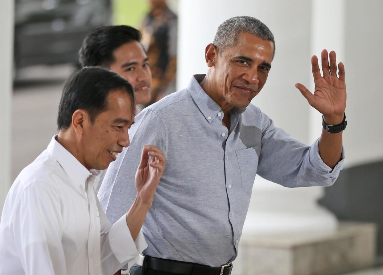 Former US president Barack Obama waves at reporters as he walks with Indonesian President Joko Widodo: AFP/Getty Images