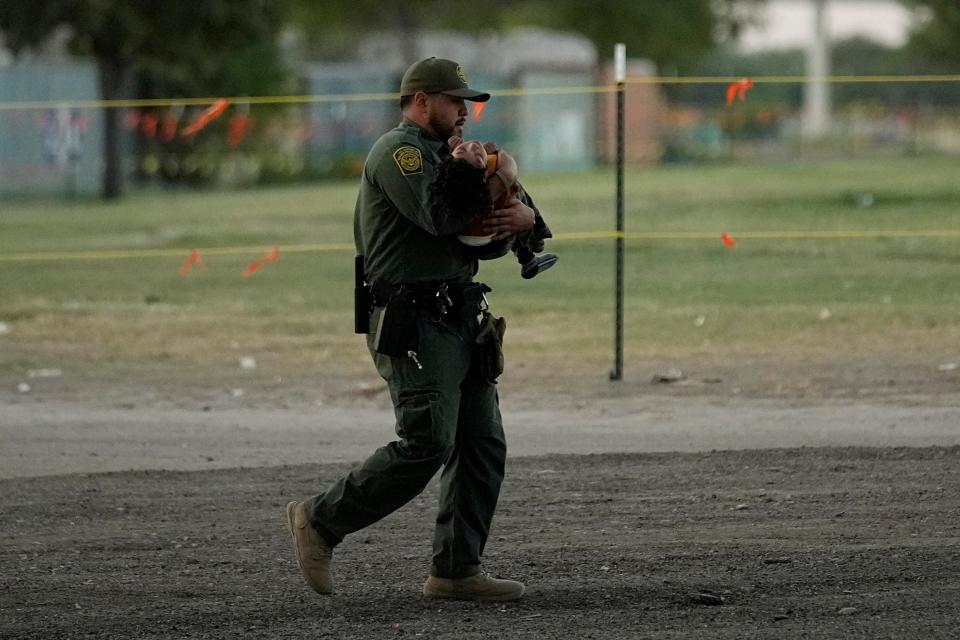 A U.S. Border Patrol agent helps a small migrant child that crossed the Rio Grande from Mexico to the U.S. with a group, Friday, Sept. 22, 2023, in Eagle Pass, Texas. (AP Photo/Eric Gay)