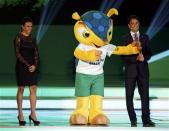 Brazil's women's team soccer player Marta (L) and former player Bebeto smile on stage with the World Cup mascot Fuleco during the draw for the 2014 World Cup at the Costa do Sauipe resort in Sao Joao da Mata, Bahia state, December 6, 2013. REUTERS/Sergio Moraes