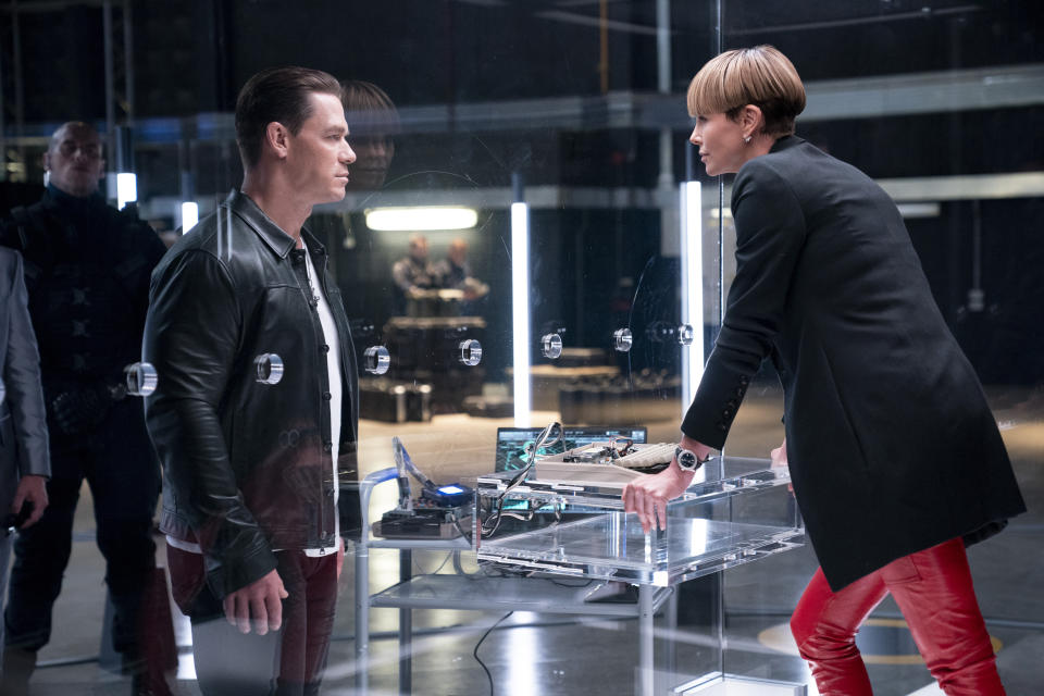 This image released by Universal Pictures shows John Cena, left, and Charlize Theron in a scene from "F9: The Fast Saga." (Giles Keyte/Universal Pictures via AP)