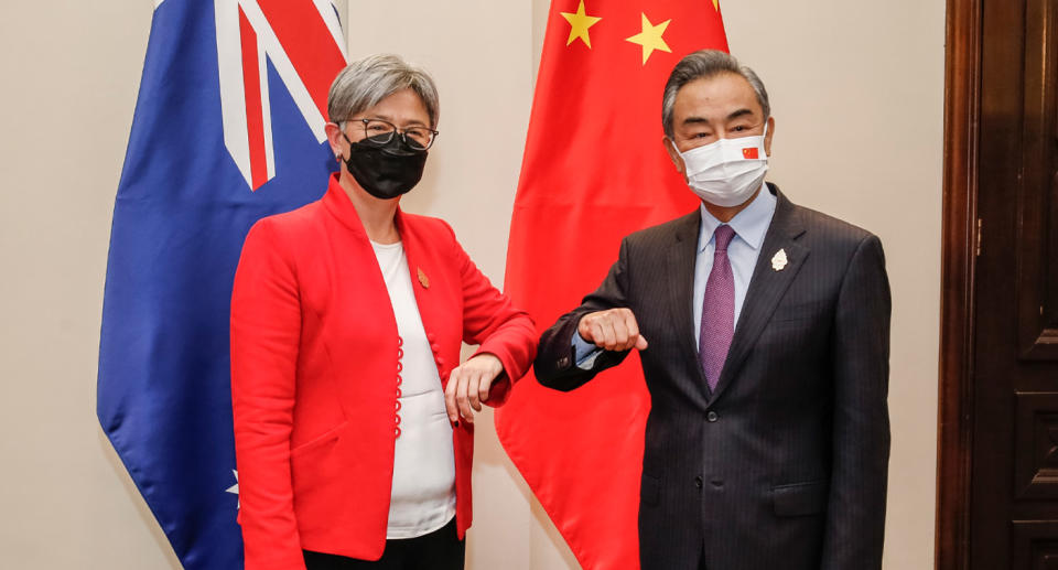 Penny Wong bumps elbows with Wang Yi on Friday.