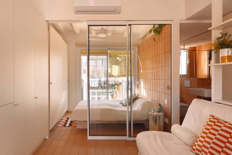 Glass door dividing bedroom and living room.