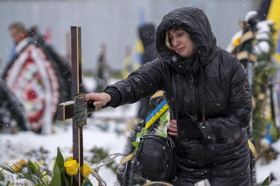 Nataliya cries at the grave of her brother Oleg Kunynets, a Ukrainian military servicemen who were killed in the east of the country, during his funeral in Lviv, Ukraine, Tuesday, Feb 7, 2023. (AP Photo/Emilio Morenatti)