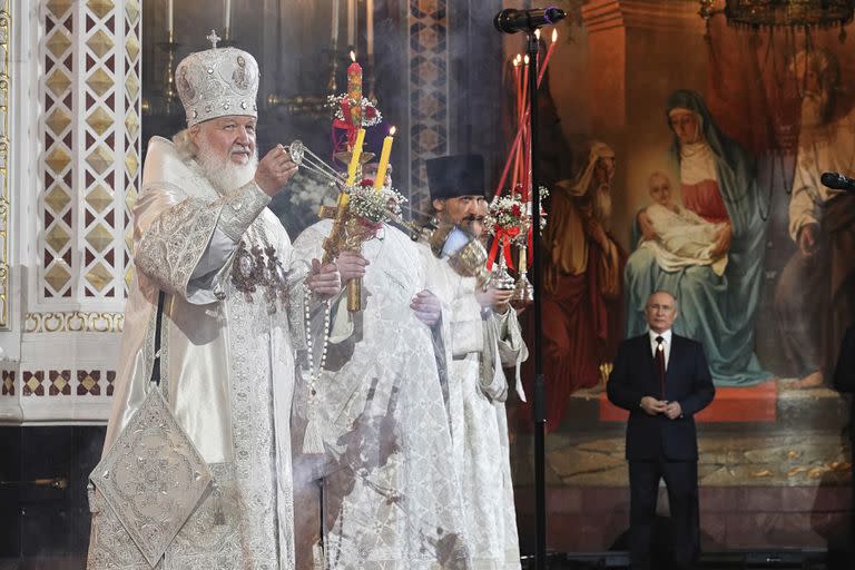 ARCHIVO - En esta foto publicada por el Servicio de Prensa de la Iglesia Ortodoxa Rusa, el patriarca de la Iglesia ortodoxa rusa, Cirilo, a la izquierda, dirige el servicio de Pascua acompañado por el presidente Vladimir Putin, al fondo a la derecha, en la Catedral de Cristo Salvador, el domingo 24 de abril de 2022, en Moscú, Rusia. 
(Oleg Varov/Russian Orthodox Church Press Service via AP)