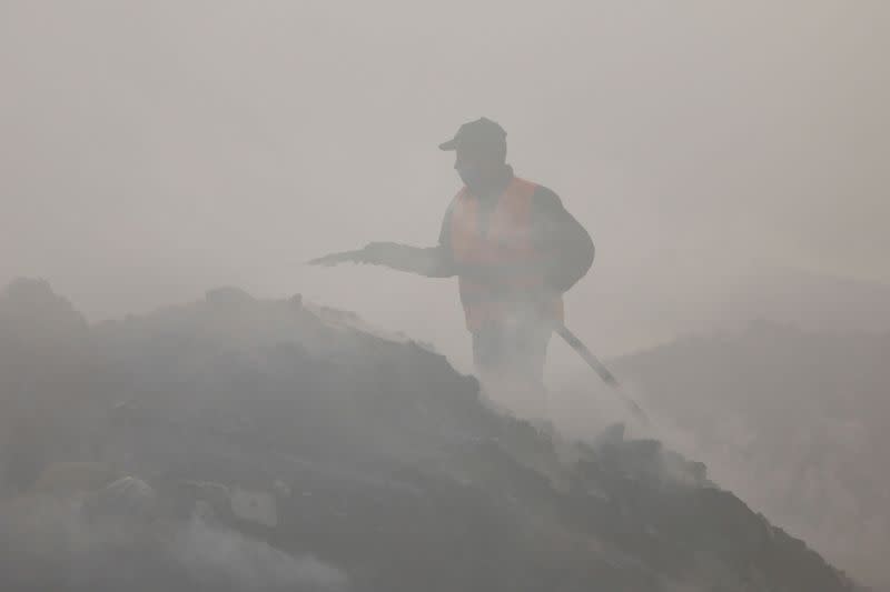 Palestinian fireman extinguishes a fire at a garbage dumping site in Juhr al-Deek, southeast of Gaza