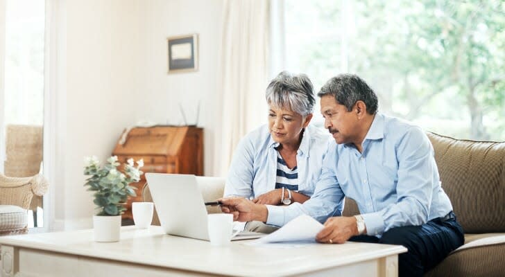 A couple looks over their retirement savings on their laptop. A Fidelity analysis found that a proportional withdrawal strategy from various accounts results in fewer taxes paid throughout a person's retirement.