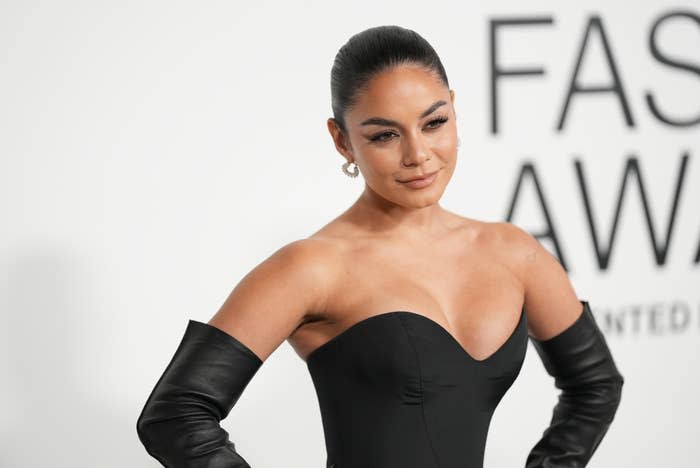 Vanessa Hudgens on the red carpet, wearing a strapless gown with matching gloves, at a fashion awards event