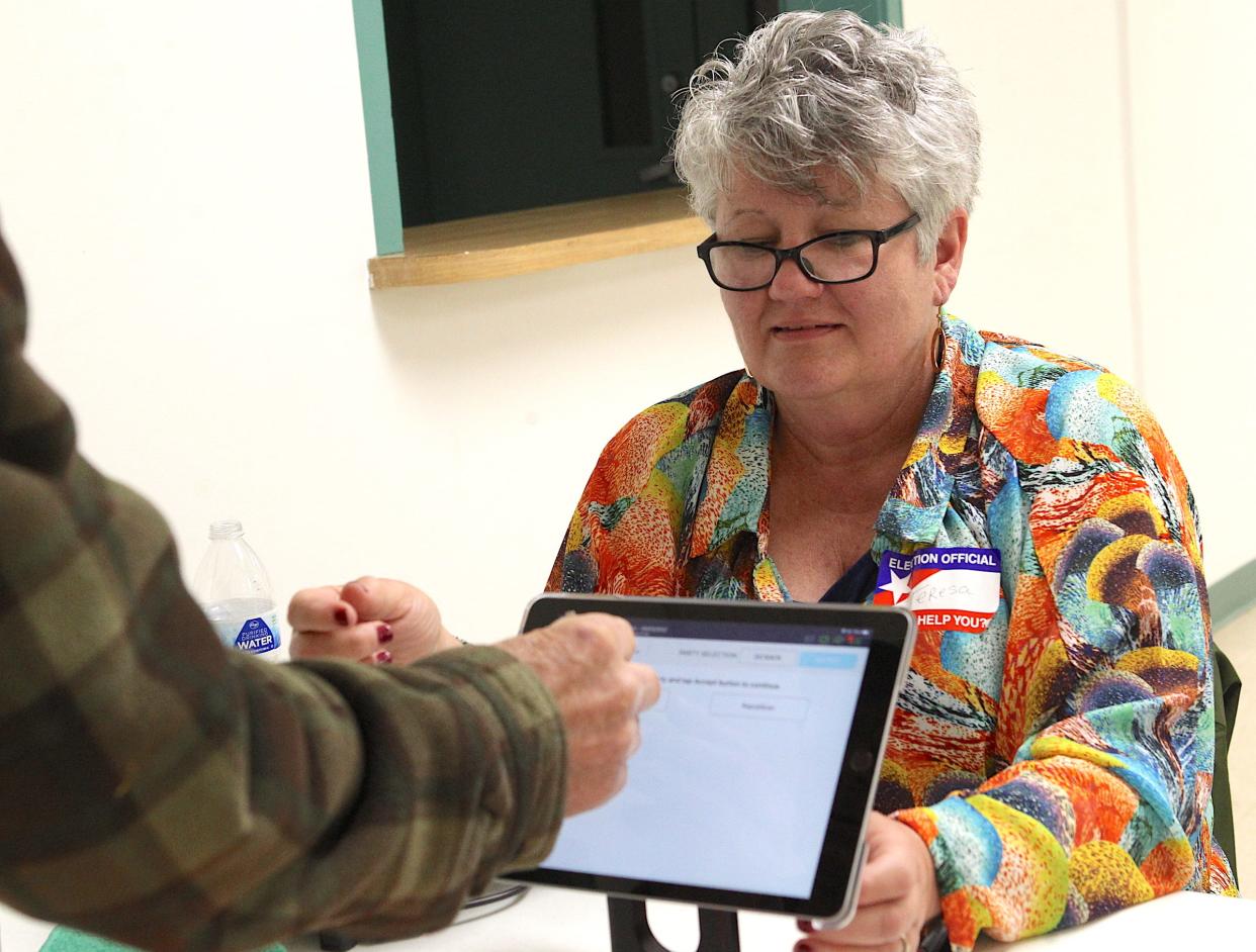 Election Voting Clerk Teresa Reynolds checks in a voter at the Mitchell Community Center Tuesday.