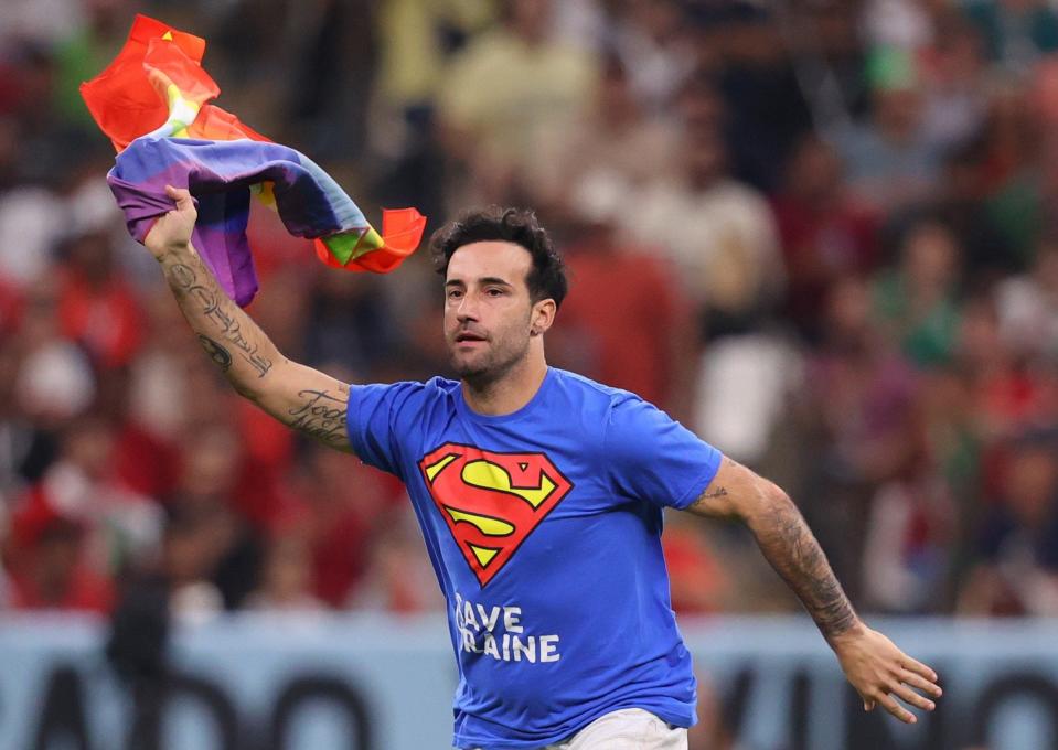 A protester on the pitch with rainbow flag and frre ukraine t shirt during the FIFA World Cup Qatar 2022 Group H match between Portugal and Uruguay at Lusail Stadium on November 28, 2022 in Lusail City, Qatar. - Marc Atkins/Getty Images