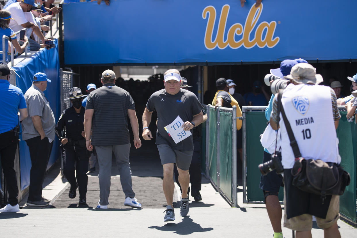 UCLA head coach Chip Kelly jogs to enter the field before an NCAA football game against Hawaii on Saturday, Aug. 28, 2021, in Los Angeles. (AP Photo/Kyusung Gong)