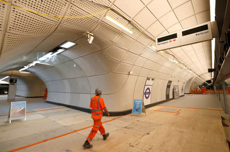 FILE PHOTO - A Crossrail worker walks in the new Farringdon underground station of the Elizabeth line, in London, Britain June 15, 2018. REUTERS/Peter Nicholls