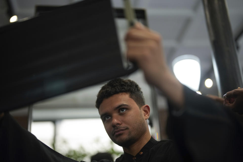 A customer checks his hairstyle in a hairdressing salon, in Paris, Wednesday, March 27, 2024. French lawmakers are debating a bill Thursday that would ban discrimination over the texture, length, color or style of someone's hair. (AP Photo/Thibault Camus)
