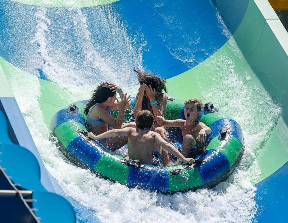 People ride a water slide.