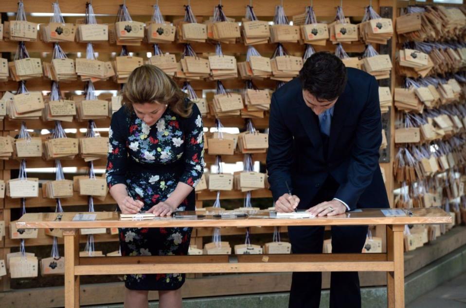 Prime Minister Justin Trudeau and wife Sophie Gregoire Trudeau write prayer tablets during their visit to the Meiji Shrine in Tokyo, Japan on Tuesday, May 24, 2016. THE CANADIAN PRESS/Sean Kilpatrick