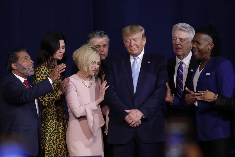 FILE - In this Friday, Jan. 3, 2020 file photo, faith leaders pray with President Donald Trump during a rally for evangelical supporters at the King Jesus International Ministry church in Miami. The conservative evangelical Christians who helped send Trump to the White House four years ago stuck by him again in 2020. But even if Trump doesn’t get a second term, some conservative Christians see reasons to celebrate in this year’s election results. (AP Photo/Lynne Sladky)