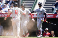 Minnesota Twins' Kyle Farmer, left, and Christian Vazquez, center, celebrate scoring off a single hit by Austin Martin with designated hitter Ryan Jeffers, right, during the fifth inning of a baseball game against the Los Angeles Angels, Sunday, April 28, 2024, in Anaheim, Calif. (AP Photo/Ryan Sun)