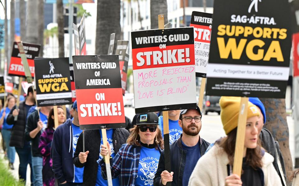 Writers on strike march with signs on the picket line on day four of the strike by the Writers Guild of America in front of Netflix in Hollywood, California on May 5, 2023.