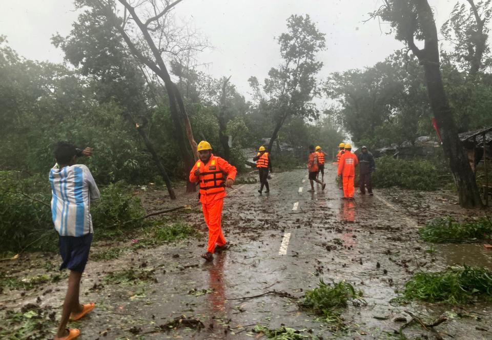 Rescue workers and locals react as they try to remove the fallen tress after a storm in Teknaf, near Cox's Bazar, Bangladesh, Sunday, May 14, 2023.