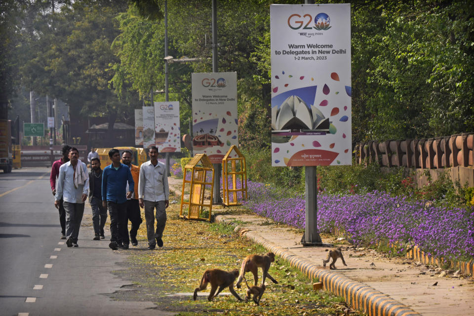 People walks past a row of welcome banners for delegates of G20 foreign ministers meeting, in New Delhi, India, Wednesday, March 1, 2023. Fractured East-West relations over Russia's war in Ukraine and increasing concerns about China's global aspirations are set to dominate what is expected to be a highly contentious meeting of foreign ministers from the world's largest industrialized and developing nations this week in India. (AP Photo/Manish Swarup)