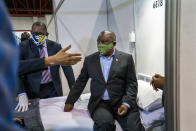 FILE- In this file photo taken Friday, April 24, 2020, South African President Cyril Ramaphosa visits the COVID-19 treatment facilities at the NASREC Expo Centre in Johannesburg, South Africa. South Africa is struggling to balance its fight against the coronavirus with its dire need to resume economic activity. The country with the Africa’s most developed economy also has its highest number of infections — more than 19,000. (AP Photo/Jerome Delay, File)