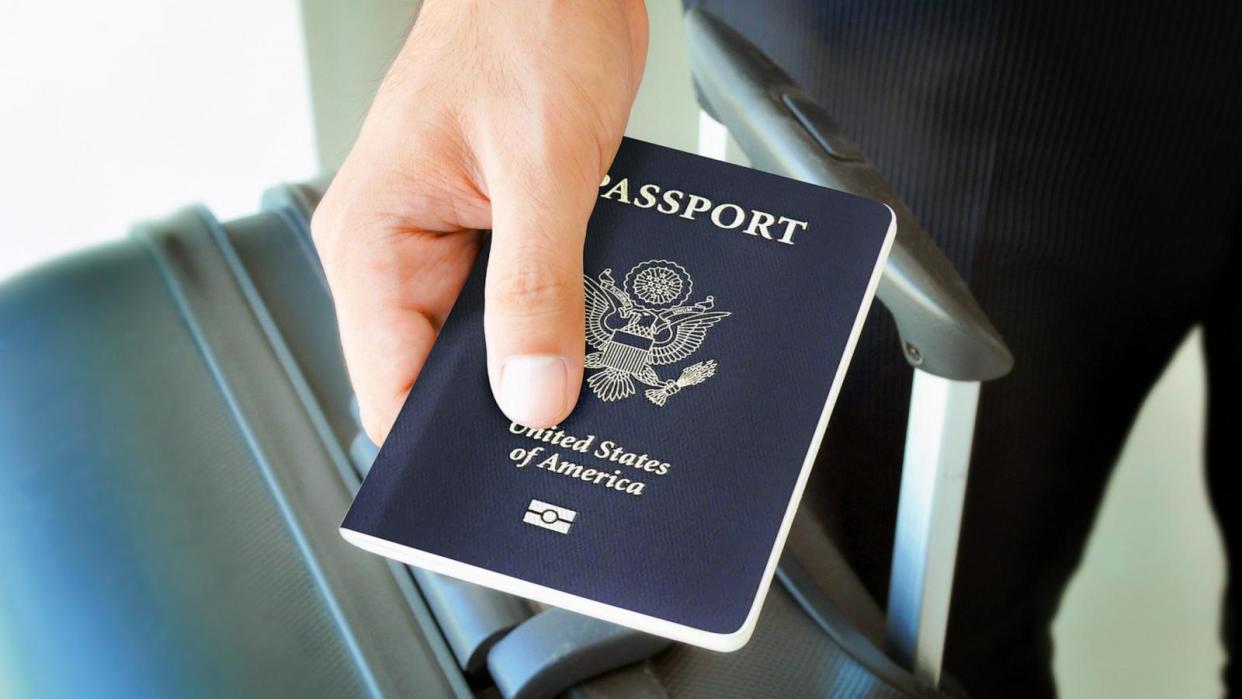 PHOTO: A hand holding a U.S. passport over a luggage. (STOCK PHOTO/Adobe Stock)