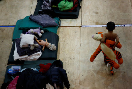 A migrant boy, part of a caravan of thousands traveling from Central America en route to the United States, plays with a toy at a temporary shelter in Tijuana, Mexico November 22, 2018. REUTERS/Kim Kyung-Hoon