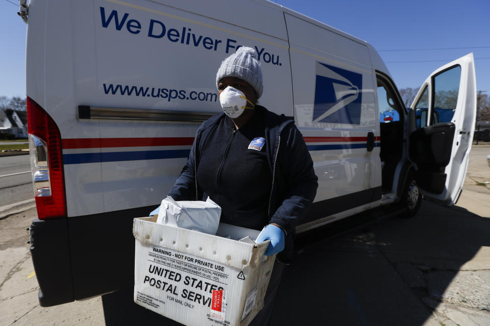 A United States Postal worker makes a delivery with gloves and a mask in Warren, Michigan, earlier this month. (Photo: ASSOCIATED PRESS)