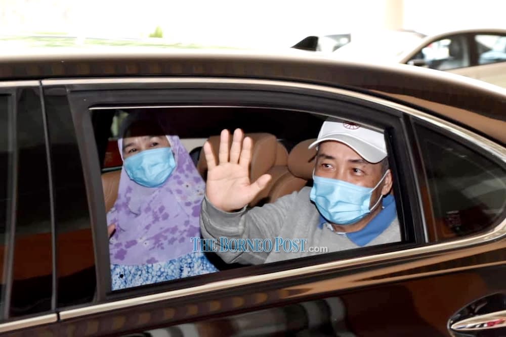 Datuk Seri Hajiji Noor and his wife Datin Seri Julia Salag wave to the medical personnel as they leave Queen Elizabeth Hospital. — Borneo Post Online pic