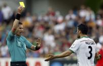 Referee Benjamin Williams of Australia shows the yellow card to Iran's Ehsan Hajisafi during the Asian Cup Group C soccer match against Bahrain at the Rectangular stadium in Melbourne January 11, 2015. REUTERS/Brandon Malone (AUSTRALIA - Tags: SOCCER SPORT)