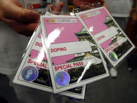 A volunteer with IAAF's local organizing committee displays the credential given to athletes who are selected for drug testing in the anti-doping offices at the 11th IAAF World Athletics Championships in Osaka August 24, 2007. The competition begins August 25. REUTERS/Brian Snyder (JAPAN