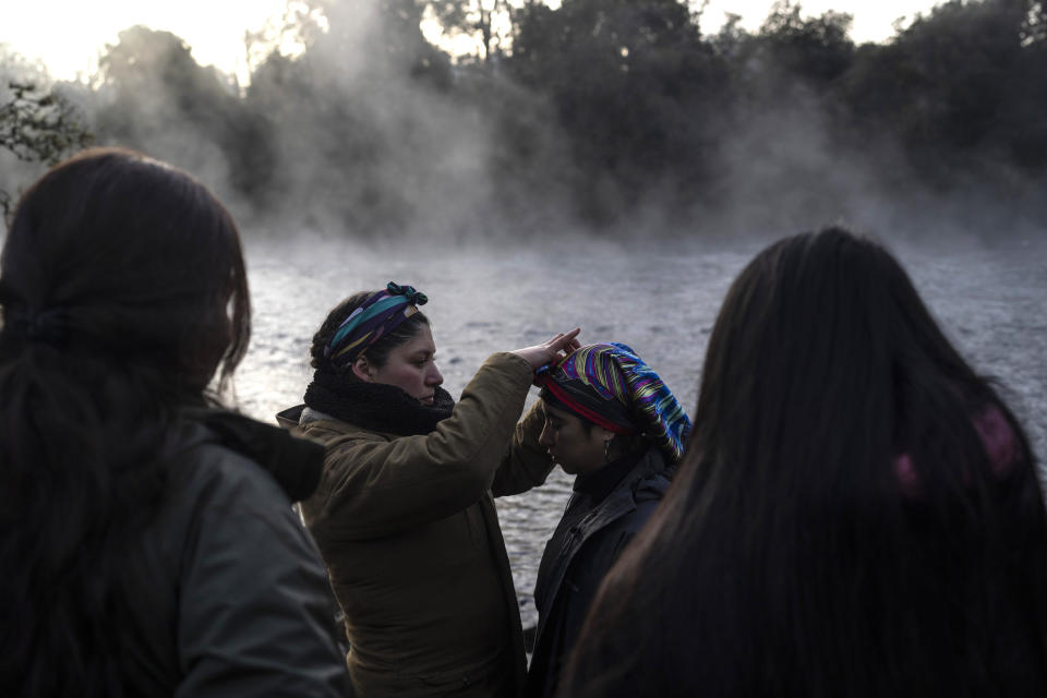 Women take part in a purification ritual in the culmination of the multiday celebration of We Tripantu, the Mapuche New Year, on the banks of the Pilmaiquen River in Carimallin, southern Chile, on Sunday, June 26, 2022. The rite is a "symbolic way to renew energy," according to Millaray Huichalaf, a machi, or healer and spiritual guide. (AP Photo/Rodrigo Abd)