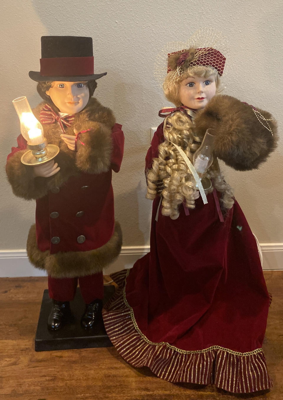 They're carrying candles, and one's wearing a top hat, and the other is in a velvet gown